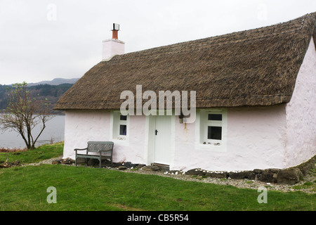 Ehemaliges Fischerhaus Schutzhütte (jetzt ein Selbstversorger Reetdachhaus im Besitz von Kilfinichan Estate) mit Blick auf Loch Scridain. Stockfoto