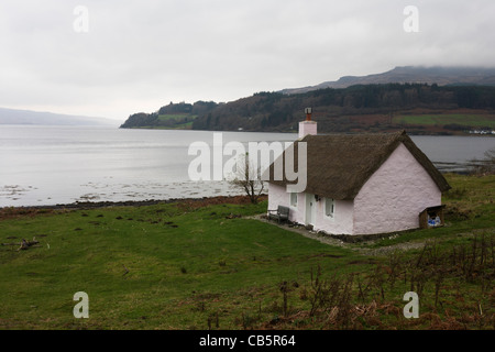 Ehemaliges Fischerhaus Schutzhütte (jetzt ein Selbstversorger Reetdachhaus im Besitz von Kilfinichan Estate) mit Blick auf Loch Scridain. Stockfoto