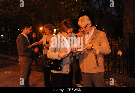 Touristen auf der Suche im Reiseführer für Richtungen in Greenwich Village Manhattan New York NYC USA Stockfoto