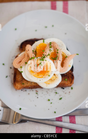 Klassische schwedische öffnen konfrontiert Sandwich aus geschnittenem gekochtem Ei garniert mit Kalles Kaviar und mit gehacktem Schnittlauch bestreut. Stockfoto