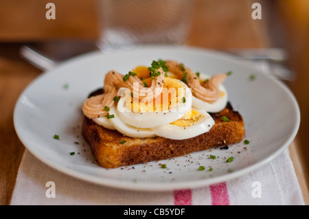 Klassische schwedische öffnen konfrontiert Sandwich aus geschnittenem gekochtem Ei garniert mit Kalles Kaviar und mit gehacktem Schnittlauch bestreut. Stockfoto