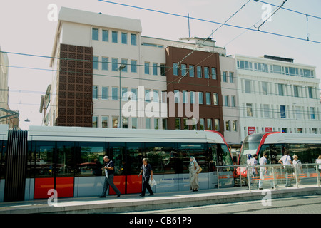 Schlanke Straßenbahnen pause an einer zentralen Istanbul Straßenbahnhaltestelle, modernen Bürogebäuden im Hintergrund Stockfoto