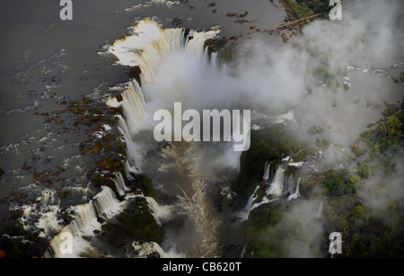 EINE LUFTAUFNAHME DES FLUSSES IGUAZU AS SENDET ES WOLKEN VON SPRAY, DA ES ÜBER DIE IGUAZU-WASSERFÄLLE BRASILIEN STÜRZT Stockfoto