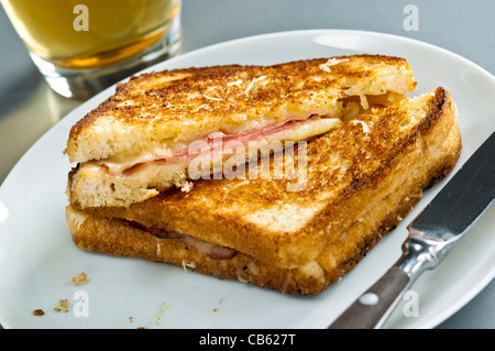 Klassische französische geröstetem Käse und Schinken Sandwich Snack, Croque Monsieur mit Glas Bier Stockfoto