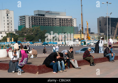 Ruhige Pause auf dem Tahrir-Platz, zwischen Demonstrationen. Das ausgebrannte ehemalige Hauptquartier der National Democratic Party ist ganz rechts. Stockfoto