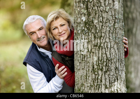Paar versteckt sich hinter Baum Stockfoto