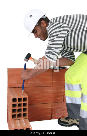 Maurer mit Hammer und Meißel Stockfoto