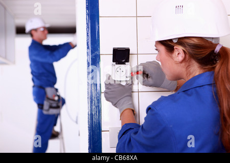 Weibliche Elektriker installieren einen kontinentalen socket Stockfoto