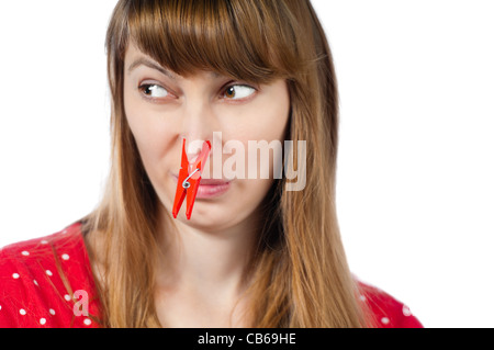 Schöne junge Frau mit roten Wäscheklammer auf der Nase. Isoliert auf weißem Hintergrund Stockfoto