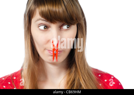 Schöne junge Frau mit roten Wäscheklammer auf der Nase. Isoliert auf weißem Hintergrund Stockfoto