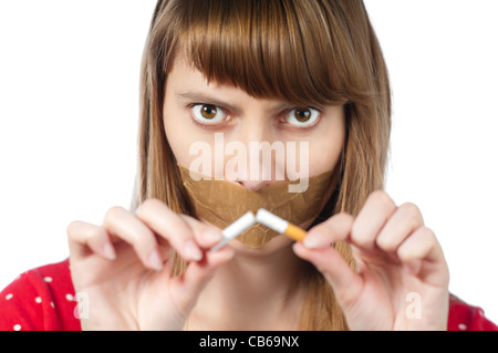 Schöne junge Frau mit Klebeband auf den Mund und gebrochenen Zigarette in der Hand. Blick in die Kamera. Aufhören zu rauchen Stockfoto