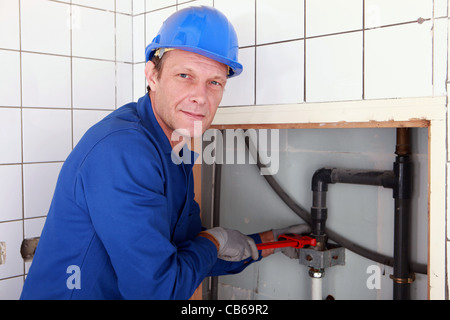 Klempner Installation von Rohren mit einem großen Schraubenschlüssel Stockfoto