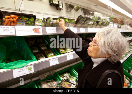 Alte Dame Shopping für Veg in einem Supermarkt Waitrose, Newmarket, Großbritannien Stockfoto