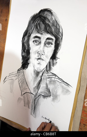 Ein Künstler auf dem Großmarkt skizziert das Porträt eines jungen Mannes. Stockfoto