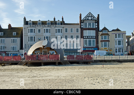 "Das Boot" Strand-Cafeteria am Strand von Weymouth mit Hotels und Bars an der Strandpromenade hinter. Stockfoto