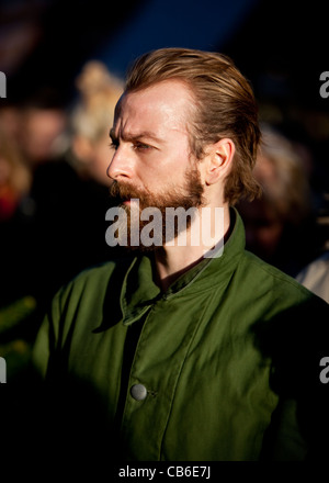 Kopfschussporträt eines bärtigen Mannes, der in der Masse steht, die nach draußen blickt, London, England, Großbritannien. Stockfoto