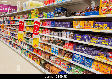 Schokolade und Süßigkeiten in den Regalen in einem Tesco Speicher Stockfoto