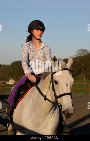 Junge Teenager-Mädchen reiten auf Grauschimmel Stockfoto