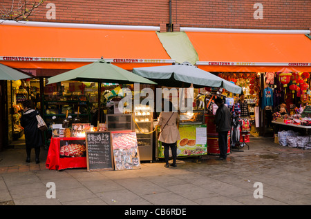 Chinesische Leute, die Einkaufsmöglichkeiten in kleinen Geschäften in Chinatown Central London UK Stockfoto