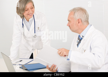 Leitender Arzt männliche Lesebuch mit professionellen Kollegin Stockfoto