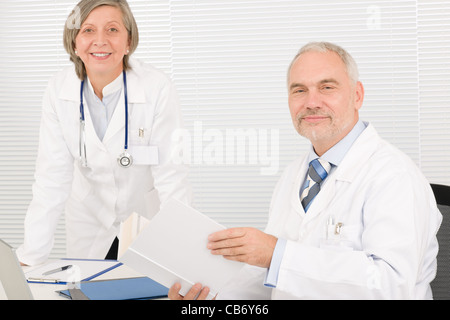 Leitender Arzt männliche Lesebuch mit professionellen Kollegin Stockfoto