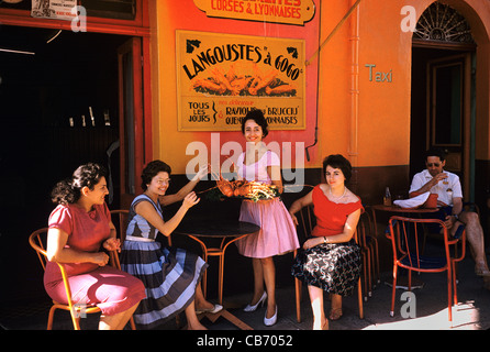 Französische Frauen der 1950er Jahre oder der 1960er Jahre vor einem Seafood-Restaurant spezialisiert auf Hummer, Porto-Vecchio, Korsika, Frankreich Stockfoto