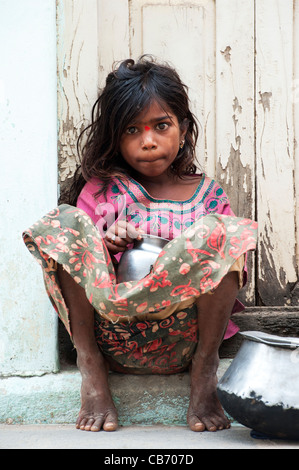 Armen indischen nomadischen Bettler Mädchen sitzen auf einem indischen Straße betteln. Andhra Pradesh, Indien Stockfoto