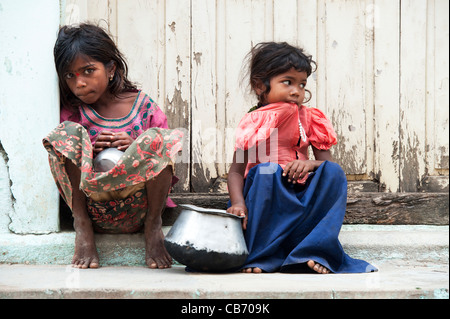 Armen indischen nomadischen Bettler Mädchen sitzen auf einem indischen Straße betteln. Andhra Pradesh, Indien Stockfoto