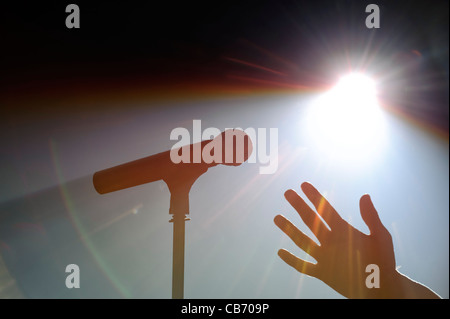 Vor Ort beleuchteten Mikrofon auf Stand und hand auf einer Bühne Stockfoto