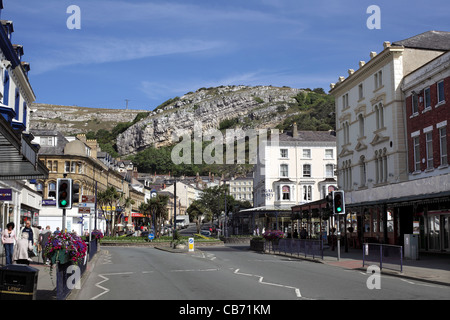 Schichten von Kalkstein auf den Great Orme steigt hinter Mostyn Street im Stadtzentrum von Llandudno, Nordwales geneigt. Stockfoto