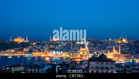 Türkei, Istanbul, beleuchtete Stadt Skyline bei Sonnenuntergang von Beyoglu über Dächer zu Sultanahmet und Moscheen mit Minaretten Stockfoto