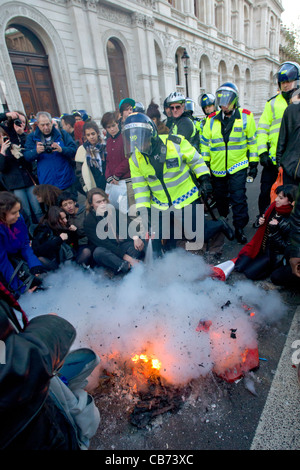 Polizei in Aufruhr Getriebe setzen, ein Feuer mit Feuerlöscher auf Whitehall, Tag X Studentendemonstration, London, England Stockfoto