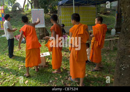 Buddhistischen Novizen werfen Darts auf ein Nebenschauplatz, Lao Neujahr (Pi Mai Lao), Luang Prabang, Laos Stockfoto