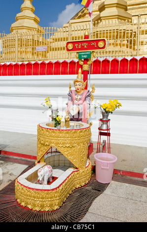 Schrein mit Blumen & Göttin mit Schild oben geschrieben in burmesischen Englisch & Thai sagen Samstag in Tachileik Shwe Dagon Pagode Stockfoto