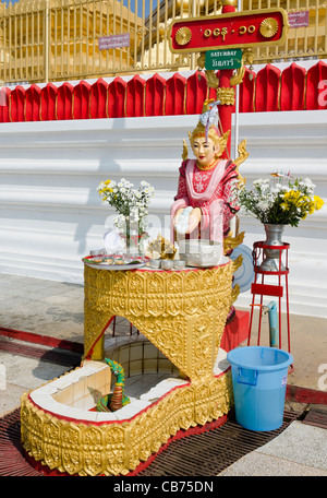 Schrein mit Blumen & Göttin mit Schild oben geschrieben in burmesischen Englisch & Thai sagen Samstag in Tachileik Shwe Dagon Pagode Stockfoto