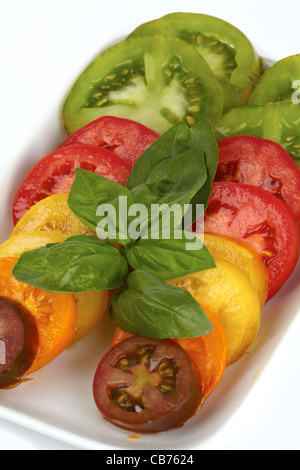 Verschiedene Sorten von Bio Tomatenscheiben auf einem Teller isoliert auf weißem Hintergrund Stockfoto