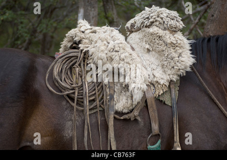 Ein patagonischen Gaucho traditionelle Lammfell Sattel, sein Seil und andere Leder-Accessoires für seine Arbeit benötigt. Stockfoto