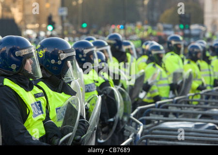 Polizei-Linie in voller Kampfausrüstung hinter Barrieren schützen Houses of Parliament, Tag X3 Studentendemonstration, London, England Stockfoto