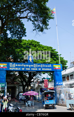 Neue "Republik der Union von Myanmar" Schild am Grenzübergang in Tachileik Myanmar mit Fahnen, Fußgänger, Wachen & Tuk tuk Stockfoto