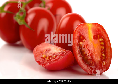 Frische rote halbe und ganze Tomaten isoliert auf weißem Hintergrund als Nahaufnahme Stockfoto
