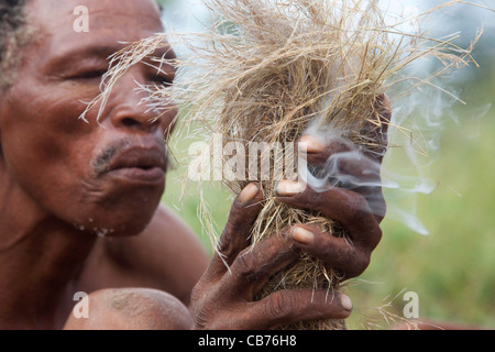 Buschmann / San in der Kalahari-Wüste in der Nähe von Ghanzi, Botswana, Afrika Feuer machen Stockfoto