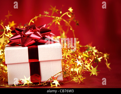 Weihnachts-Geschenk und Glitter-Folie Stern auf rotem Grund Stockfoto