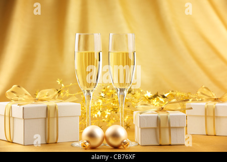 Glas Sekt mit Geschenkboxen und Weihnachtskugeln. Stockfoto