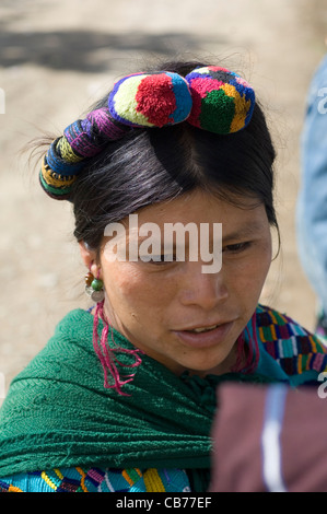 indigenen mittelamerikanischen indische Frau in traditioneller gewebte Kleidung und mit farbigen Zöpfen und Pompons in ihrem Haar. Stockfoto