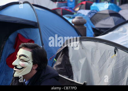 London-Lager, außerhalb der St. Pauls Cathedral, London, UK zu besetzen. Mann, Teil der Anonymous-Bewegung mit Guy Fawkes Maske Stockfoto