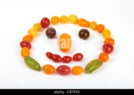 Eine lustige Smiley-Gesicht sind Satz von kleinen bunten Bio-Tomaten isoliert auf weißem Hintergrund Stockfoto