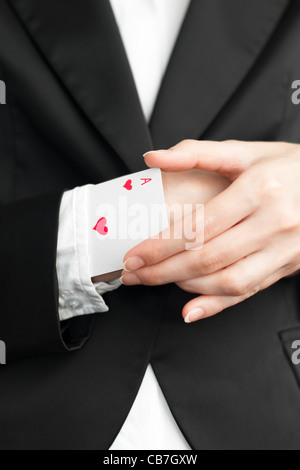 junge Geschäftsfrau Herzass aus dem Ärmel ihres Anzugs herausziehen Stockfoto