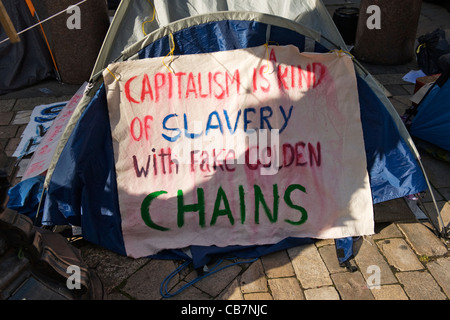 Str. Pauls Kathedrale Tent City besetzen London Aktivisten Banner Kapitalismus ist eine Art von Sklaverei mit goldenen Ketten Fake Stockfoto