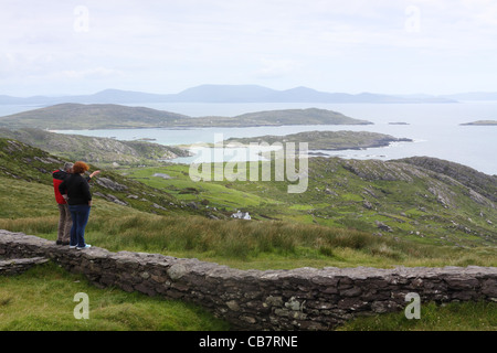 Touristen auf der Suche in Kenmare Bay am Aussichtspunkt am Coomatloukane auf der Iveragh-Halbinsel, County Kerry, Irland Stockfoto