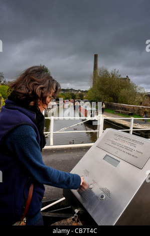 Junge Frau Betrieb eine elektrische Brücke, Boote der Leeds-Liverpool Kanal, Yorkshire, Großbritannien in Skipton weitergeben können. Stockfoto